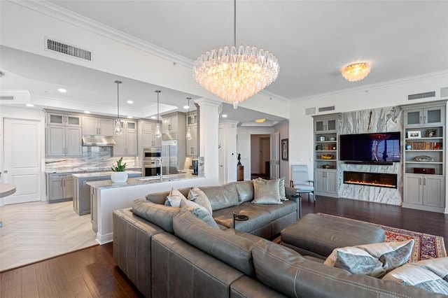 living room featuring ornamental molding, a fireplace, parquet flooring, and visible vents