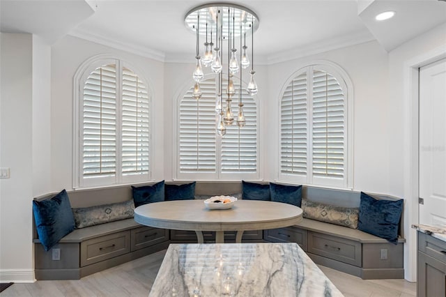 dining area featuring breakfast area, a notable chandelier, ornamental molding, and baseboards