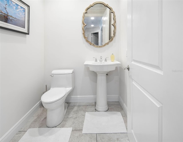 bathroom with toilet and baseboards