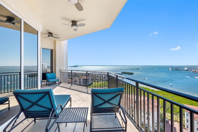 balcony featuring a water view and ceiling fan