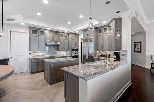 kitchen featuring stainless steel appliances, gray cabinets, visible vents, and a sink