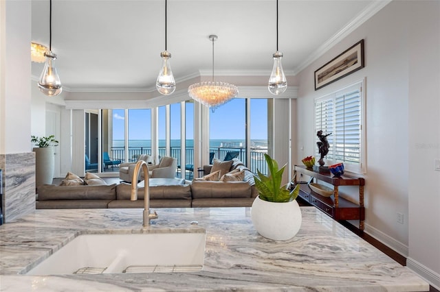 living room featuring a water view, baseboards, and crown molding