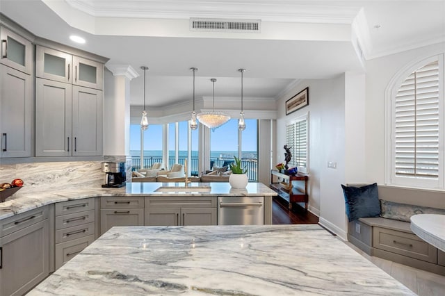 kitchen with light stone counters, visible vents, gray cabinets, and crown molding