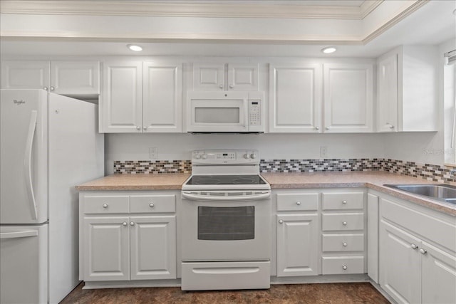 kitchen featuring light countertops, white appliances, and white cabinetry