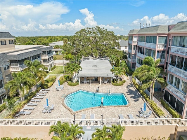 community pool with a patio area and fence