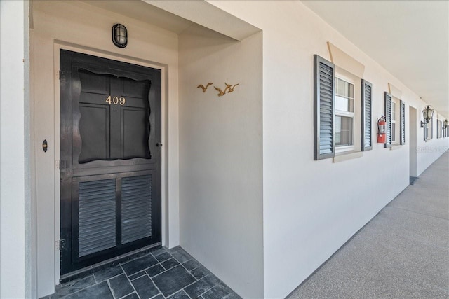 view of exterior entry featuring stucco siding