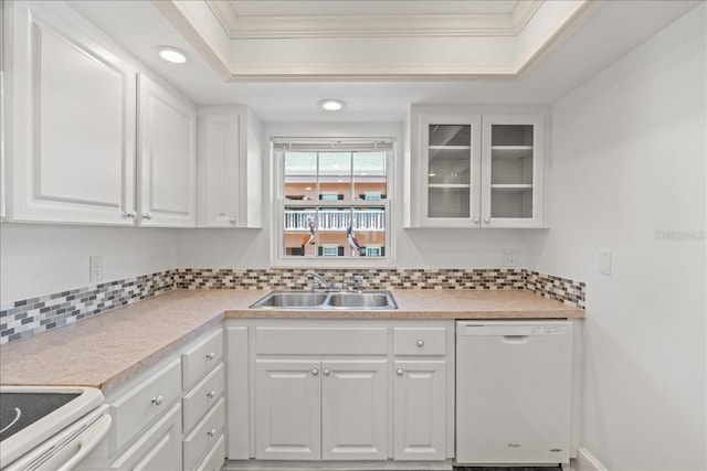 kitchen with a raised ceiling, glass insert cabinets, white cabinetry, a sink, and dishwasher