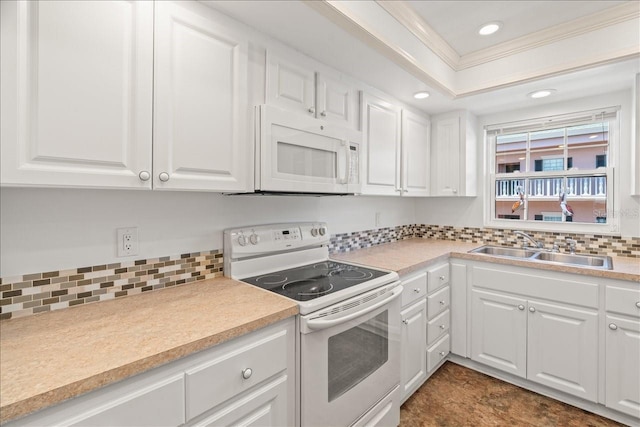 kitchen with white appliances, a sink, white cabinetry, light countertops, and crown molding