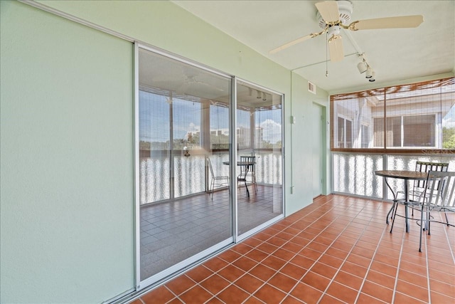 unfurnished sunroom with ceiling fan, visible vents, and rail lighting