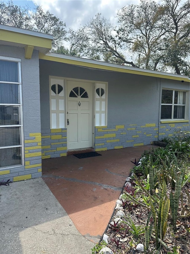 doorway to property featuring stucco siding