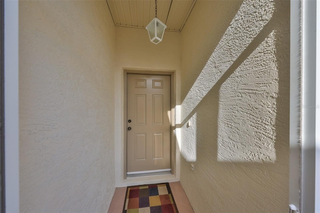 doorway to property featuring stucco siding