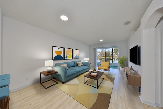 living room featuring recessed lighting, baseboards, visible vents, and light wood finished floors