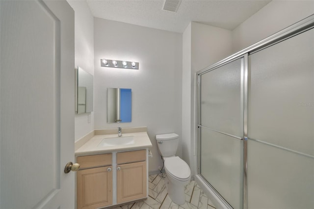 full bathroom featuring a textured ceiling, toilet, visible vents, vanity, and an enclosed shower