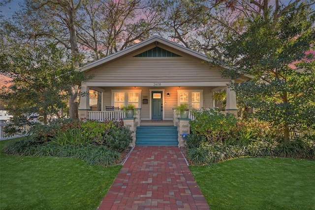 view of front of property featuring a front yard and covered porch