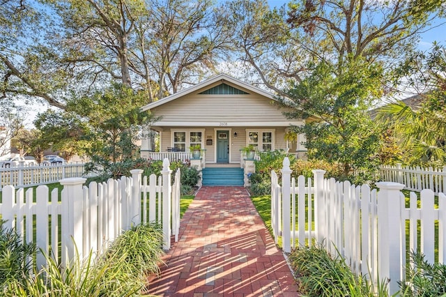 bungalow featuring a fenced front yard and a porch