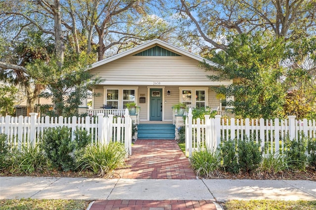 bungalow with a fenced front yard and a porch