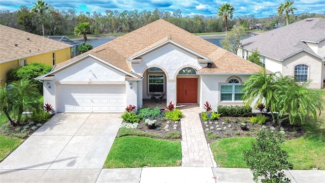 view of front of home with a garage, driveway, a shingled roof, and stucco siding