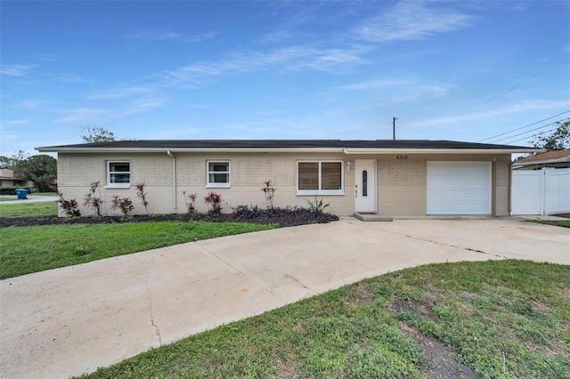 ranch-style home with a front yard, brick siding, driveway, and an attached garage