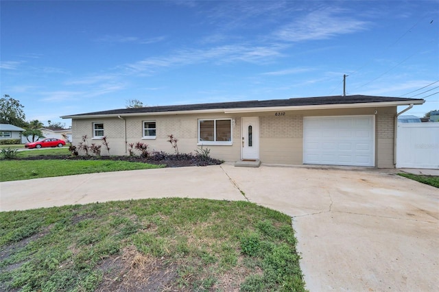 ranch-style home with a garage, driveway, a front lawn, and brick siding