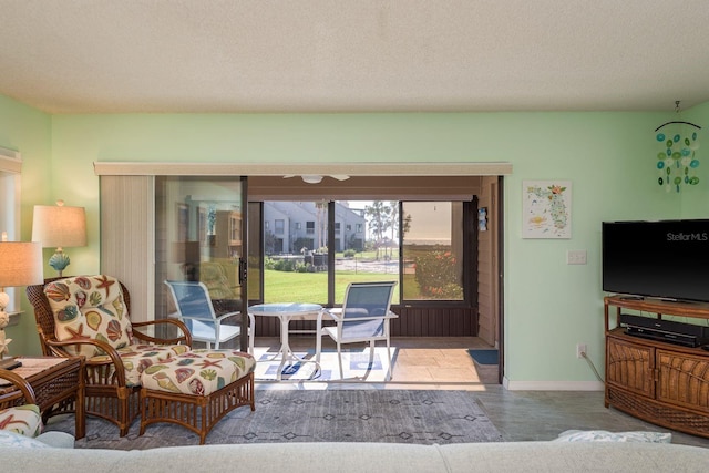 living room with a textured ceiling and baseboards