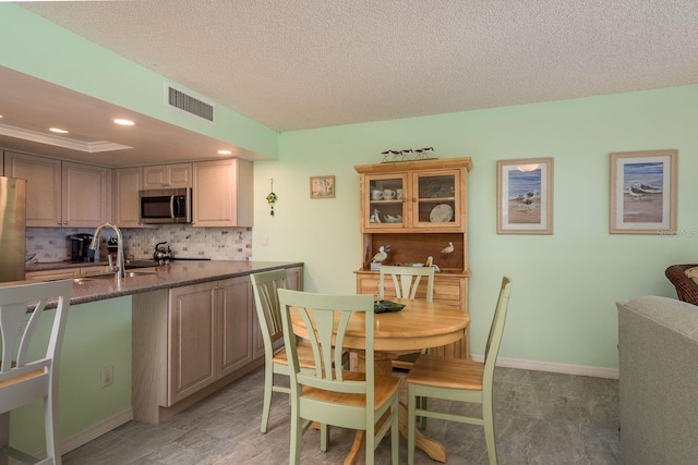 kitchen with tasteful backsplash, baseboards, visible vents, appliances with stainless steel finishes, and a sink