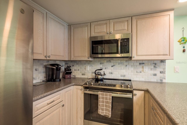 kitchen with tasteful backsplash and appliances with stainless steel finishes