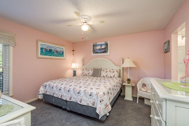 bedroom with a textured ceiling, dark colored carpet, ceiling fan, and baseboards