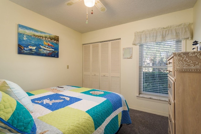 carpeted bedroom with ceiling fan, a closet, baseboards, and a textured ceiling