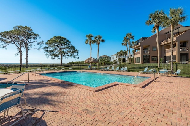 community pool featuring fence and a patio