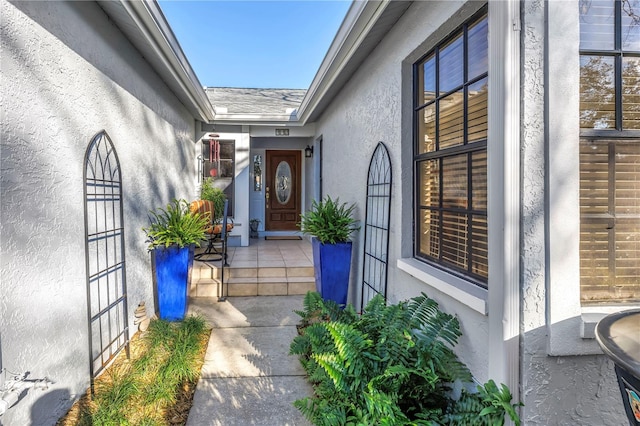 doorway to property featuring stucco siding