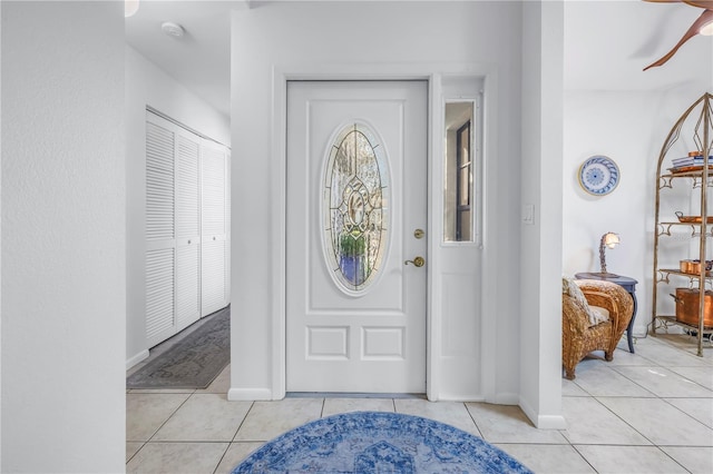 entrance foyer featuring light tile patterned floors, baseboards, and a ceiling fan