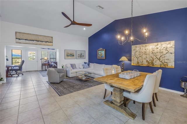 dining room with high vaulted ceiling, ceiling fan with notable chandelier, visible vents, and light tile patterned flooring