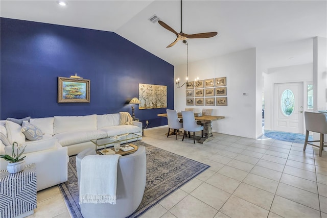 living room featuring lofted ceiling, light tile patterned floors, visible vents, and ceiling fan with notable chandelier