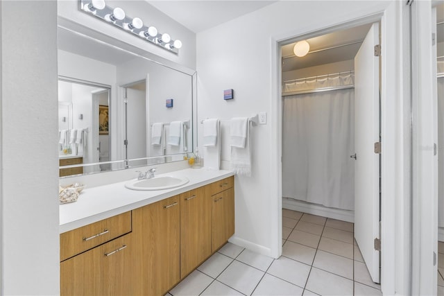 full bathroom featuring tile patterned flooring, vanity, and baseboards