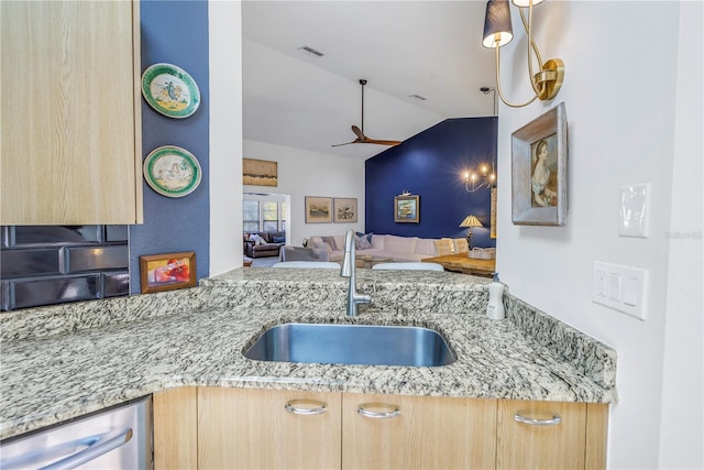 kitchen featuring light stone counters, a sink, visible vents, open floor plan, and dishwasher
