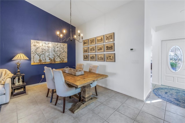 tiled dining room featuring a chandelier, high vaulted ceiling, and baseboards