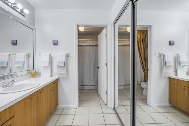 full bath with tile patterned flooring, vanity, and toilet