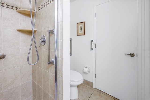 bathroom featuring a shower stall, toilet, and tile patterned floors