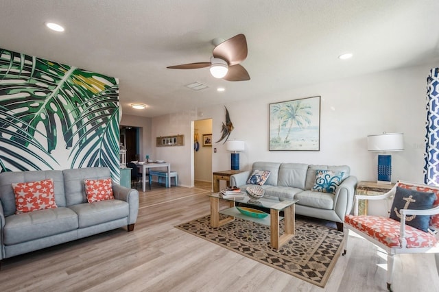 living room with a textured ceiling, a ceiling fan, wood finished floors, and recessed lighting