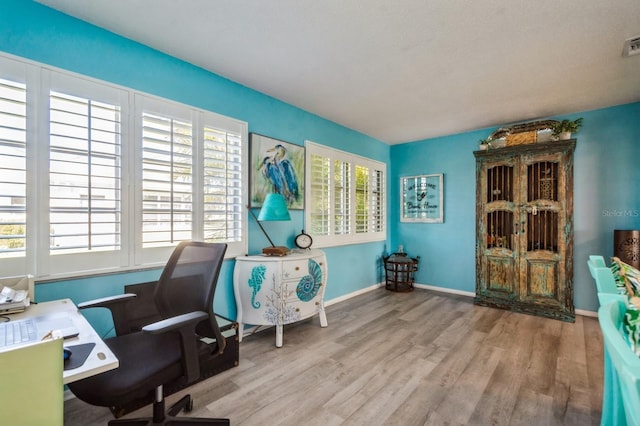 office featuring visible vents, baseboards, and wood finished floors