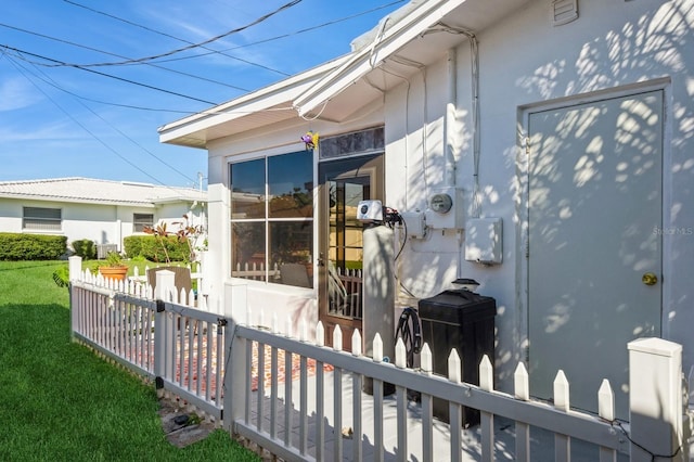 view of side of property featuring a lawn and fence