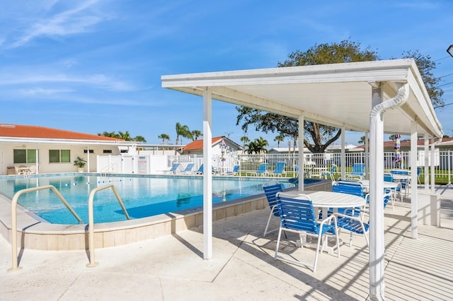 community pool featuring fence and a patio