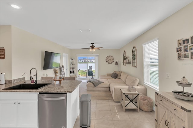 kitchen featuring light tile patterned floors, ceiling fan, a sink, dishwasher, and open floor plan