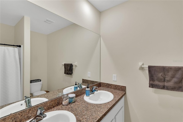 full bath featuring double vanity, toilet, and a sink