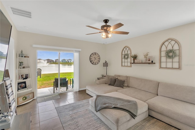 tiled living area with visible vents, baseboards, and ceiling fan