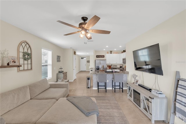 living room with light tile patterned floors, baseboards, ceiling fan, and recessed lighting