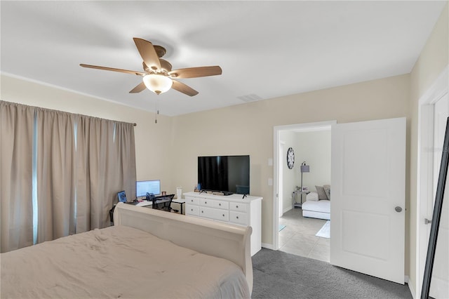 bedroom featuring visible vents, baseboards, light carpet, light tile patterned floors, and a ceiling fan