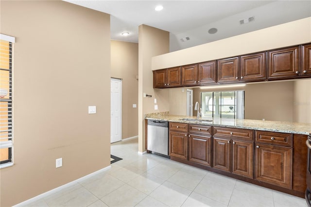 kitchen featuring visible vents, dishwasher, light stone countertops, a sink, and light tile patterned flooring