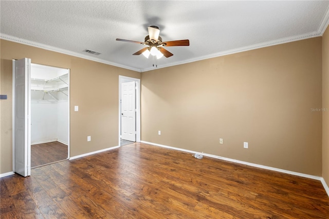 unfurnished bedroom featuring baseboards, dark wood-type flooring, visible vents, and crown molding