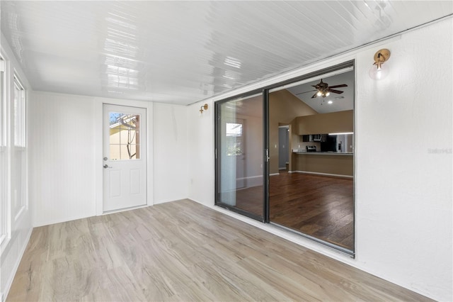 spare room featuring lofted ceiling, ceiling fan, and light wood finished floors